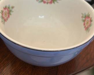 Hall's Superior Blue rose parade Bowl — Hall's Superior kitchenware mixing bowl in a soft blue glaze with floral inner decal accents. Heavy stoneware construction with a rounded form and slightly flared rim, marked on the base "HALL'S SUPERIOR QUALITY KITCHENWARE MADE IN U.S.A.". Measures approximately 6.5 inches tall with a 10.5 inch diameter, a useful size for prep and serving in the living room sale. Good vintage condition with typical light crazing and surface wear on the base rim consistent with age and use.
