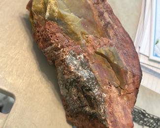 Petrified Wood Specimen — Large hand specimen of a jasper/chert-type silica nodule showing banded red, yellow and brown colors with a semi-polished fracture face and rough iron-stained exterior. Good visual display piece for a rock or mineral collection and suitable for cutting or lapidary work; the specimen shows natural weathering and minor surface pits but no modern repairs. Approximate measurements and estimated weight are provided below — useful for display or hobby lapidary projects.