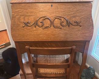 Oak Ladies Drop-Front Secretary — Charming oak drop-front secretary with an attached oval mirror and carved scrollwork on the fall-front; ideal for a living room or entry. The piece is constructed of quarter-sawn oak with a hinged writing surface that reveals multiple pigeonholes and a small drawer for organization. Measures approximately 42 in tall (to top of mirror), 28 in wide, and 18 in deep when closed; lightweight, graceful cabriole legs make it easy to place. Overall in good condition with minor surface wear and light scuffs consistent with normal use; hardware and hinges are intact and the lock has its key.