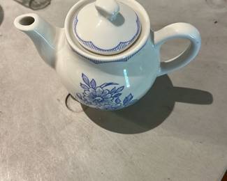 Williamsburg Lodge Small Teapot — Williamsburg Lodge small ceramic teapot with blue floral transfer decoration and scalloped lid trim, stamped on the base "Williamsburg Lodge Williamsburg, Virginia." A compact, classic souvenir piece ideal for display or light use; shows expected surface wear and light staining on base from age and use. Measures small and lightweight—suitable for a decorative tea service or collection of regional pottery.