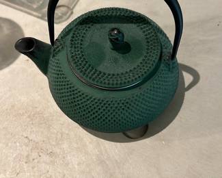 Cast Iron Green Tetsubin Teapot — Small green cast-iron tetsubin-style teapot with textured hobnail surface and removable lid; metal handle and short spout make it suitable for table display or light brewing. Base shows a maker's mark impressed into the iron (as seen in photos) and a mottled green enamel finish over dark iron. Good used condition with minor surface wear consistent with age; no visible cracks or major chips to the finish. Compact size is easy to handle and ideal for collectors of Japanese-style cast-iron teapots or as a decorative kitchen accent.