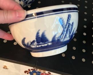 Porcelain Rice Bowl — Blue Willow Porcelain Rice Bowl — classic blue-on-white transferware rice bowl with a traditional willow scene and twin blue rim lines. Lightweight porcelain, shows normal surface wear and faint rim fritting/chips visible in photos but no major cracks; glaze remains glossy inside. A simple, usable piece for everyday table service or to add to a Blue Willow collection; measures small and stacks easily with similar bowls.
