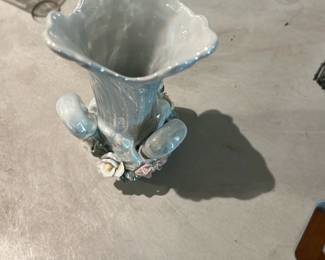 Porcelain Floral Figural Bud Vase — Delicate porcelain bud vase with a scalloped trumpet top and applied figural floral decoration at the base. Pale glazed finish with tiny hand-modeled roses and scroll accents; light surface wear consistent with age but no obvious chips or cracks visible in photos. Compact decorative piece that works as a small flower holder or shelf accent; shown on a table for scale.