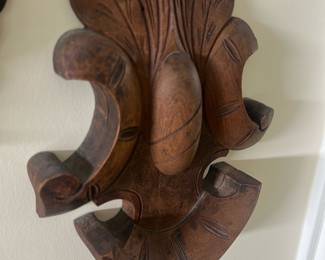 Carved Wood Wall — Decorative carved wood wall hook with a foliate, scroll-style design—perfect for a sun room accent. Crafted from stained hardwood with hand-carved grooves and three curved hooks integrated into a single backplate. Overall piece is medium-sized and lightweight, suitable for hanging hats, light coats, or decorative items; measurements are estimated below. Good estate-condition with minor surface wear and patina consistent with age but no major damage visible. Solid construction and attractive carved detail add classic character to casual or traditional interiors.