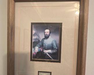 Framed Portrait stamp — Framed color portrait of a Civil War–era officer matted with a small stamp or vignette mounted below the image. The piece is set in a simple oak-tone wooden frame with double matting and glass; mat shows light age toning and the frame has minor wear consistent with display. A tasteful, wall-ready historical print suitable for a study or collection of military prints; overall good condition with intact glass and secure backing.