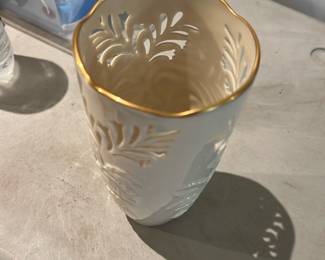 Lenox Vase Gold Rim — Decorative white porcelain vase with a scalloped gold-gilt rim and raised leaf motif cutout pattern. The piece appears to be a lightweight ceramic/porcelain with glossy glaze and gilt trim; ideal as a small accent or for faux floral arrangements. Photos show no chips or obvious cracks, just minor surface wear consistent with gentle use. Measures small to medium tabletop size and would display well on a shelf or mantle.