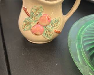Roseville Ohio Pottery Creamer — Roseville Ohio Pottery creamer with applied peaches and leaves motif in polychrome glaze. The small pitcher displays the textured off-white body and raised fruit decoration typical of Roseville production; ideal for collectors of American art pottery. Photos show light surface wear and a few glaze crazing lines but no obvious chips or repairs. Measures small and decorative — perfect as a display piece or for serving cream.
