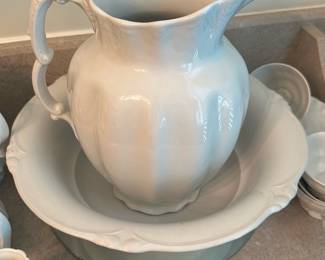Johnson Bros Royal Ironstone Pitcher Set — Large white Royal Ironstone pitcher with matching bowl, marked Johnson Bros England on the underside. Classic Victorian-style molded form with scalloped rim and ornate handle; heavy ironstone construction lends durability and substantial presence for display or serving. Marking confirms Johnson Bros production; set shows typical light surface wear and minor glaze roughness at rim edges consistent with age but no large chips or breaks visible in photos. Ideal for dining-room display or as a decorative centerpiece; measurements listed below are estimated from photos.