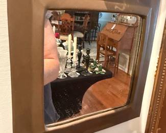 Square Bronze Framed Wall Mirror — Simple square wall mirror with a broad bronze-colored molded frame and slightly aged mirror surface. The frame shows a matte bronze finish with beveled inner edge; mirror glass has minor spotting and age-related foxing visible in reflections. Lightweight, versatile piece suitable for hallway or powder room; mounts on the back (hardware not shown). Overall good functional condition with cosmetic wear consistent with age.