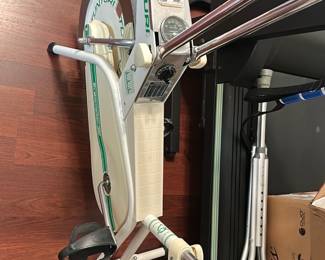 Tunturi Exercise Bike — Tunturi stationary exercise bike in white with green trim and analog console. Solid steel frame with adjustable resistance dial and basic pedal straps; console shows speed/odometer-style gauge and simple readouts. Good used condition with expected surface wear and scuffs from normal use; pedals and handlebars appear intact. Measures compactly for home use and suitable for general cardio workouts.