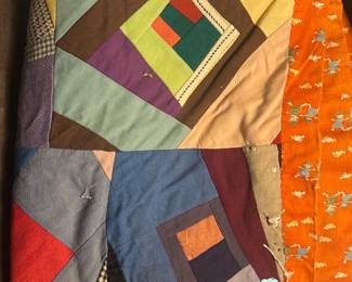 Handmade Patchwork Quilt Orange Border — Hand-sewn patchwork quilt with colorful log-cabin style blocks and a bright orange printed border featuring small figures. The quilt appears handmade from mixed cotton and fabric scraps with visible hand-stitching and signs of wear/repairs in places (small holes and thinning shown). Good for decorative use, layering, or textile craft; lightweight and soft with a charming folk-art look. Measurements are estimates from photos; see dimensions below.