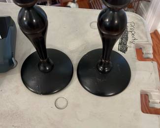 Pair Black Wooden Candlesticks — Pair of turned wooden candlesticks finished in black paint with classic baluster profiles and round bases. Sturdy, simple design suits traditional or modern decor; each shows light surface wear and small scuffs to the finish consistent with use. No visible maker marks or labels on the photos; ideal as a matching pair for mantel or table display. Measures compactly and is easy to move or repurpose as decorative accents.
