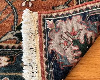 V23 - $95. Wool area rug with rust/blue colors. Measures 72.5” x 50”.