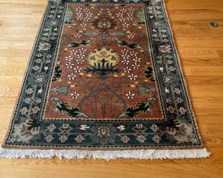 V23 - $95. Wool area rug with rust/blue colors. Measures 72.5” x 50”.