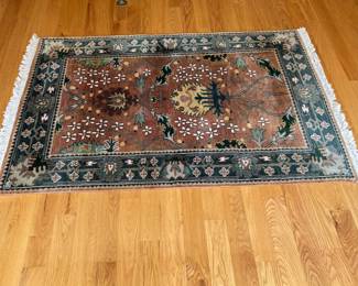 V23 - $95. Wool area rug with rust/blue colors. Measures 72.5” x 50”.