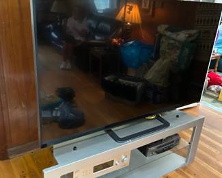 #53 Vizio Flatscreen Model P65TUIV2 - 65" TV w/remote $175.00 #55 Laminate Silver W/Glass Shelf TV Stand - 54x19x19 $20.00