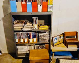 Metal Bookshelf with National Geographic Magazines & Child’s Wood Chair Tags: vintage National Geographic magazines, metal bookshelf, magazine storage boxes, Scholastic Book Fairs box, child’s wood chair, framed art A sturdy metal shelving unit holds a large collection of vintage magazines, including National Geographic issues neatly organized in colorful storage boxes. Nearby, a charming small wood child’s chair and framed artwork add to the mix — great finds for collectors and readers alike.