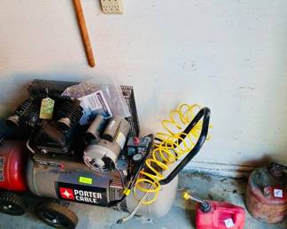 **Photo — Porter Cable Air Compressor & Vintage Gas Cans** **Tags:** Porter Cable air compressor, 135 PSI compressor, coiled air hose, vintage metal gas can, plastic gas can, garage power equipment A rolling Porter Cable 135 PSI air compressor with coiled air hose is ready to power up any garage project. Nearby, both a vintage rusted metal gas can and a modern plastic gasoline can add practical extras to this lot.