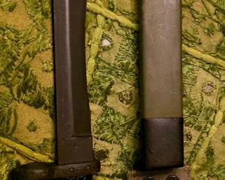 U.S. M7 bayonet with an M8A1-style scabbard, made for the M16 rifle. The black checkered grip, muzzle-ring guard, locking pommel, and green fiberglass scabbard