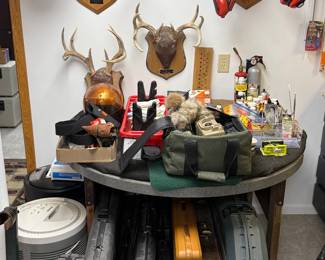 Multiple Empty Gun Cases, Deer Antlers, Gun Cleaning Supplies and Coyote Calls, Vintage Orange Motorcycle Helmet, Hearing Protection.