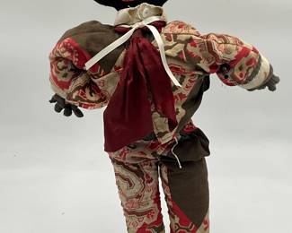 handmade folk art rag doll with a black knitted head and embroidered features.