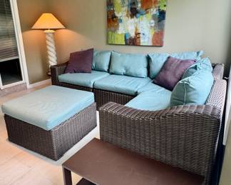 Furniture set with dark brown woven wicker sectional sofa and matching ottoman.
