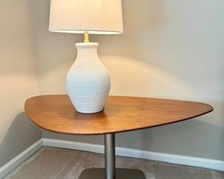 Asymmetrical, triangular wood side table on a single metal pedestal.
