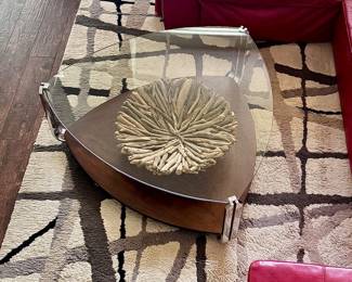 Area rug with a plush texture and abstract geometric design of intersecting dark brown and grey lines over light beige.