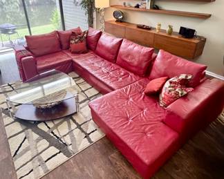 Sectional sofa features vibrant crimson-red leather with a smooth finish and tufted seat cushions