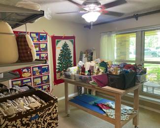 Sewing room full of goodies! Material, sewing, cross stitch and quilting patterns, batting, and many sewing notions.