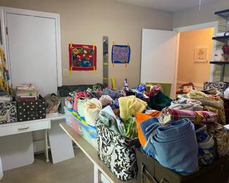 Sewing room full of goodies! Material, sewing, cross stitch and quilting patterns, batting, and many sewing notions.