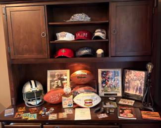 Sports memorabilia display — signed footballs, caps, framed photos