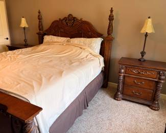 Ornate carved wood queen bed with matching nightstands and lamps