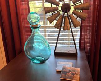 Decorative metal windmill and teal glass jug decor