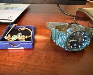 Gold charm bracelet and men's sport watch
