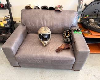 Gray leather loveseat and motorcycle helmet