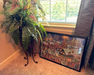 Faux fern plant on iron stand and framed art