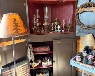primitiove corner cabinet with oil lamps and cabin decor