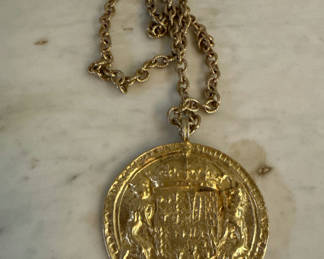 Lot 220: Accessocraft coin Gold-toned round pendant necklace with crest