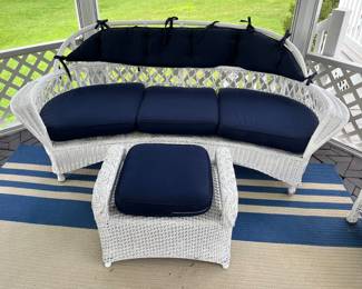 White wicker patio furniture includes this sofa and ottoman.