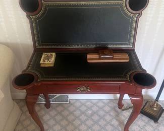 Game table with black leather surface and cabriole legs.