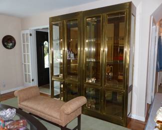 Pair of mid-century brass curio cabinets, upholstered rolled arm bench