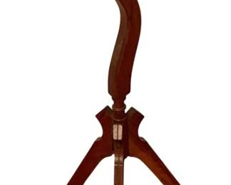 97 - Wood Plant Stand w/ Tripod Base 33"x12" (Description): Wooden plant stand featuring a round dished top with raised rim, supported by a gracefully curved serpentine pedestal. The base consists of three splayed legs joined at a central hub. The stand displays a warm reddish-brown finish characteristic of cherry or mahogany wood. Measures 33 inches tall by 12 inches in diameter.