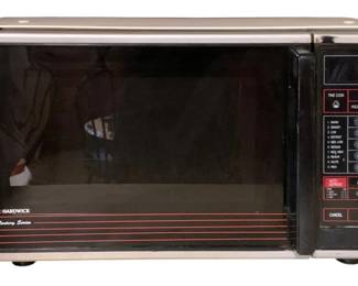 75 - Hardwick Century Series Microwave Oven (Description): Hardwick Century Series microwave oven featuring a silver and black exterior with chrome trim accents. The control panel includes a digital number pad, multiple power level settings, and function buttons including time cook, auto start, hold time, clock set, auto defrost, and one touch cook options. The front door features decorative red pinstripe detailing. Measures 11.5"x19.5"x12.5".