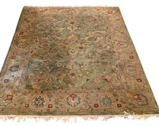 248 - Large Area Rug 119"x89" (Description): Large area rug featuring an Oriental-style design with an all over floral and palmette pattern on a green field. The rug is framed by a wide tan border decorated with large-scale floral medallions in shades of blue, burgundy, and cream. Finished with fringe on both ends. Measures 119 inches by 89 inches. shows wear and some fading