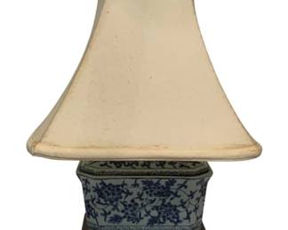 126 - Blue/White Lamp 18" (Description): Blue and white ceramic lamp measuring 18 inches. The lamp features a decorative porcelain base with traditional floral patterns in blue on a white ground, mounted on a wooden stand with a cream-colored fabric shade. Used as is electric/electronic/mechanical item. No guarantee all components, untested.
