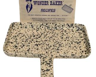 66 - Dr. Douglas Wonder Baker Pan w/ Recipe Book (Description): Dr. Douglas Wonder Baker pan with accompanying recipe booklet. The pan features a cream-colored speckled enamel finish with dark blue or black splatters and a single handle for easy serving. The recipe booklet describes it as "the most versatile cooking and serving pan ever," noting it keeps food hot for up to 45 minutes and cuts baking time for many recipes. Measures 11.5" x 10.5".