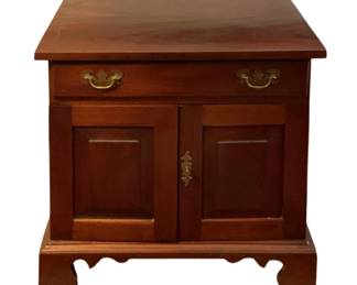 120 - Wood Cabinet Stand 25"x25"x18" (Description): Wood cabinet stand featuring a single drawer with brass bail pulls and a two-door cabinet below with decorative brass hardware. The piece rests on a bracket base with shaped feet. Measures 25 inches by 25 inches by 18 inches.
