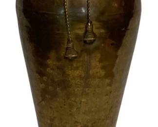 44 - Hammered Brass Vase w/ Tassel Decoration (Description): A handsome hammered brass vase featuring a flared rim and tapered body. The vase is adorned with a decorative twisted rope collar at the neck, from which hang two ornamental brass tassels. The surface displays a lovely aged patina with characteristic hammer marks throughout. Measures 15.5 inches tall.