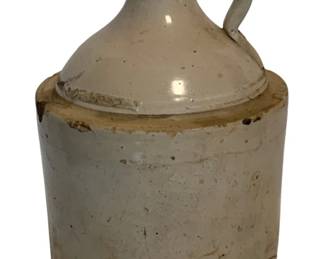 19 - Antique Salt Glazed Stoneware Jug 12"x7" (Description): Antique stoneware jug featuring a cream-colored salt glaze finish with a classic beehive shape and applied loop handle. The jug shows characteristic wear consistent with age, including exposed stoneware at the shoulder and base. Measures 12 inches tall by 7 inches in diameter.